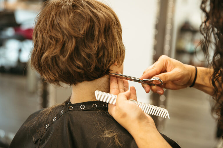 Woman with short, straight hair getting a haircut. This salon has expertise in a range of hair types.